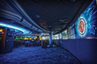 Analysts work at rows of monitors inside a modern cyber security operations centre.