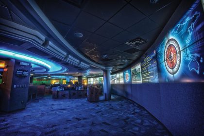 Analysts work at rows of monitors inside a modern cyber security operations centre.